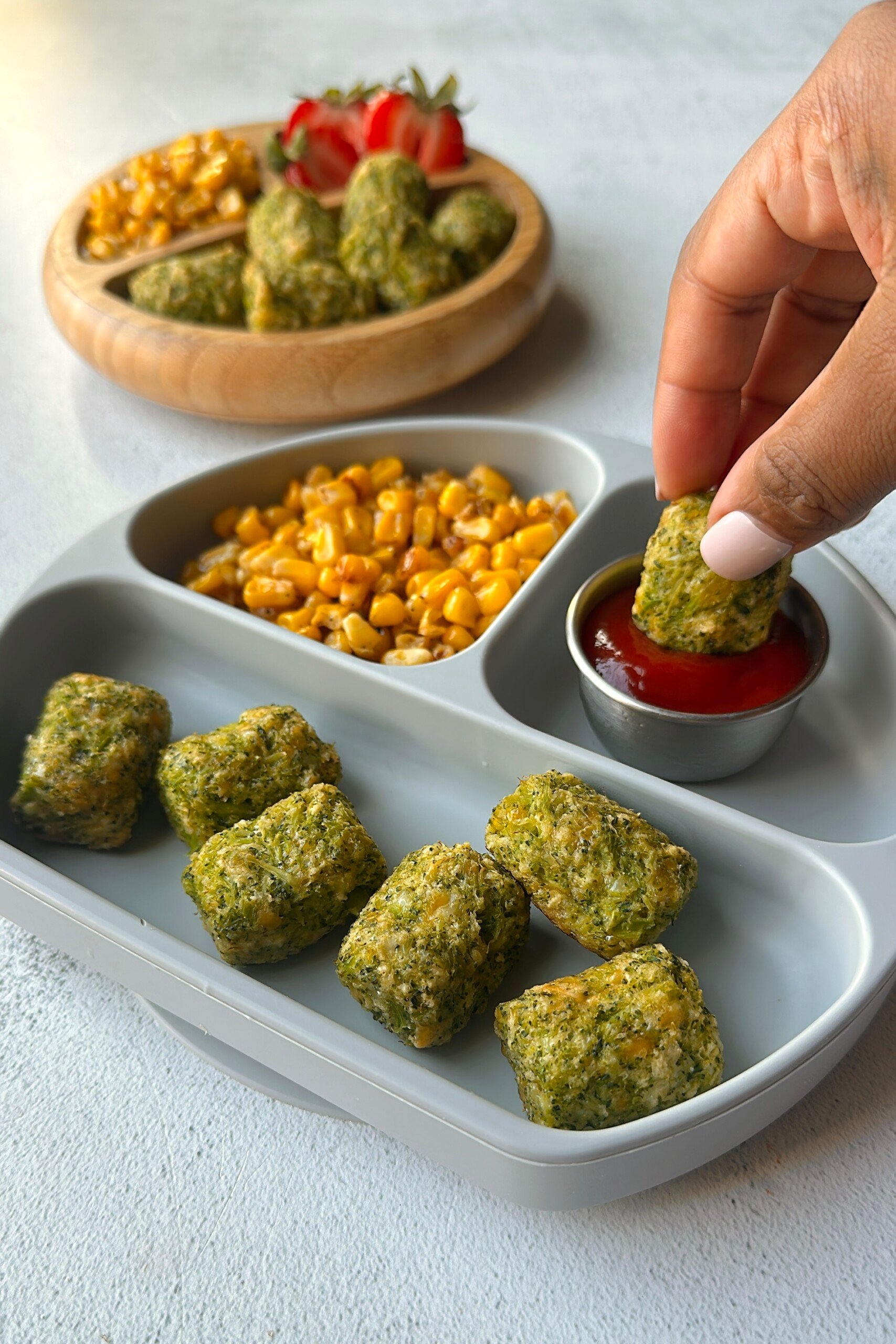 Broccoli tots served with ketchup, corn, and berries.
