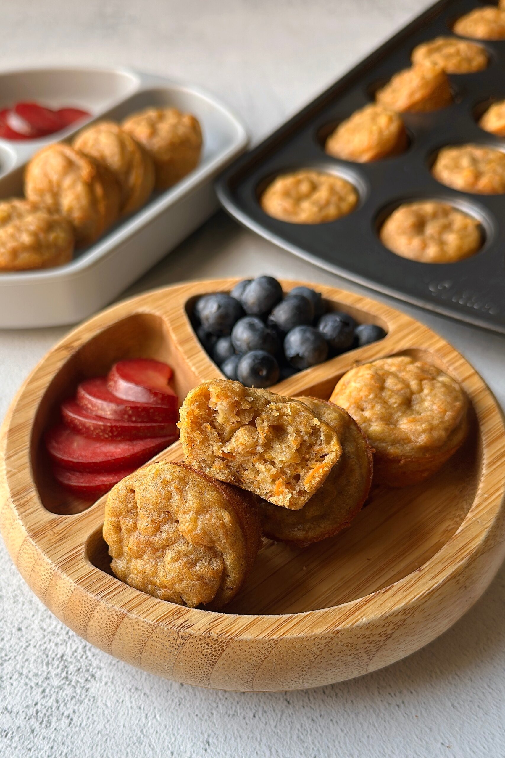 Banana carrot muffins served with blueberries and plums.