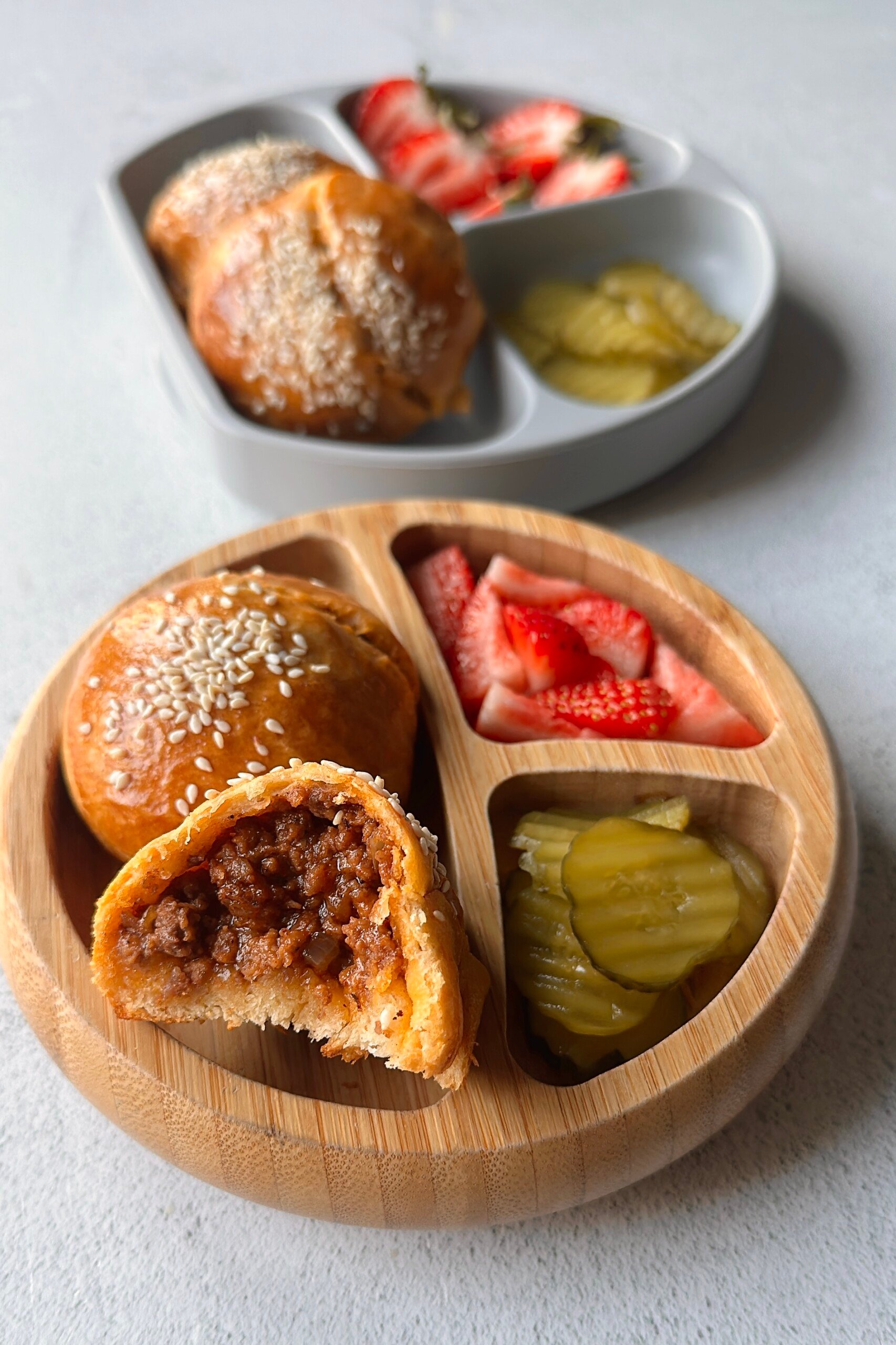 Cheeseburger bombs served with pickles and strawberries.