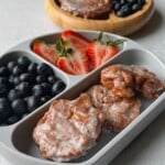 Applesauce fritters served with berries.
