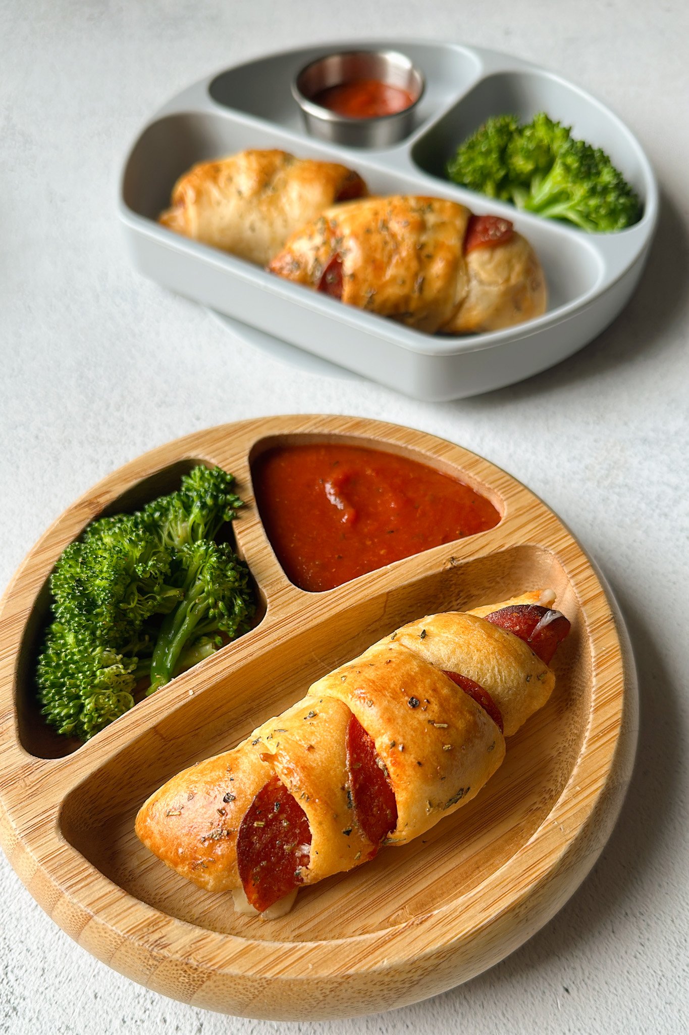 Crescent pizza rolls served with broccoli and marinara sauce.