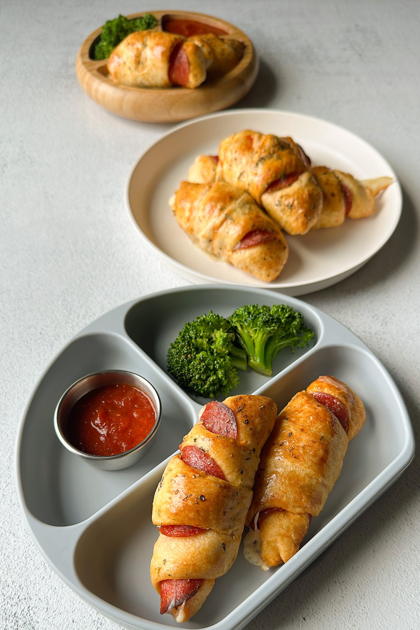Crescent pizza rolls served with broccoli and marinara sauce.