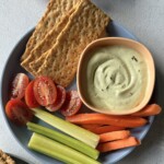Avocado cottage cheese dip served with veggies and crackers.