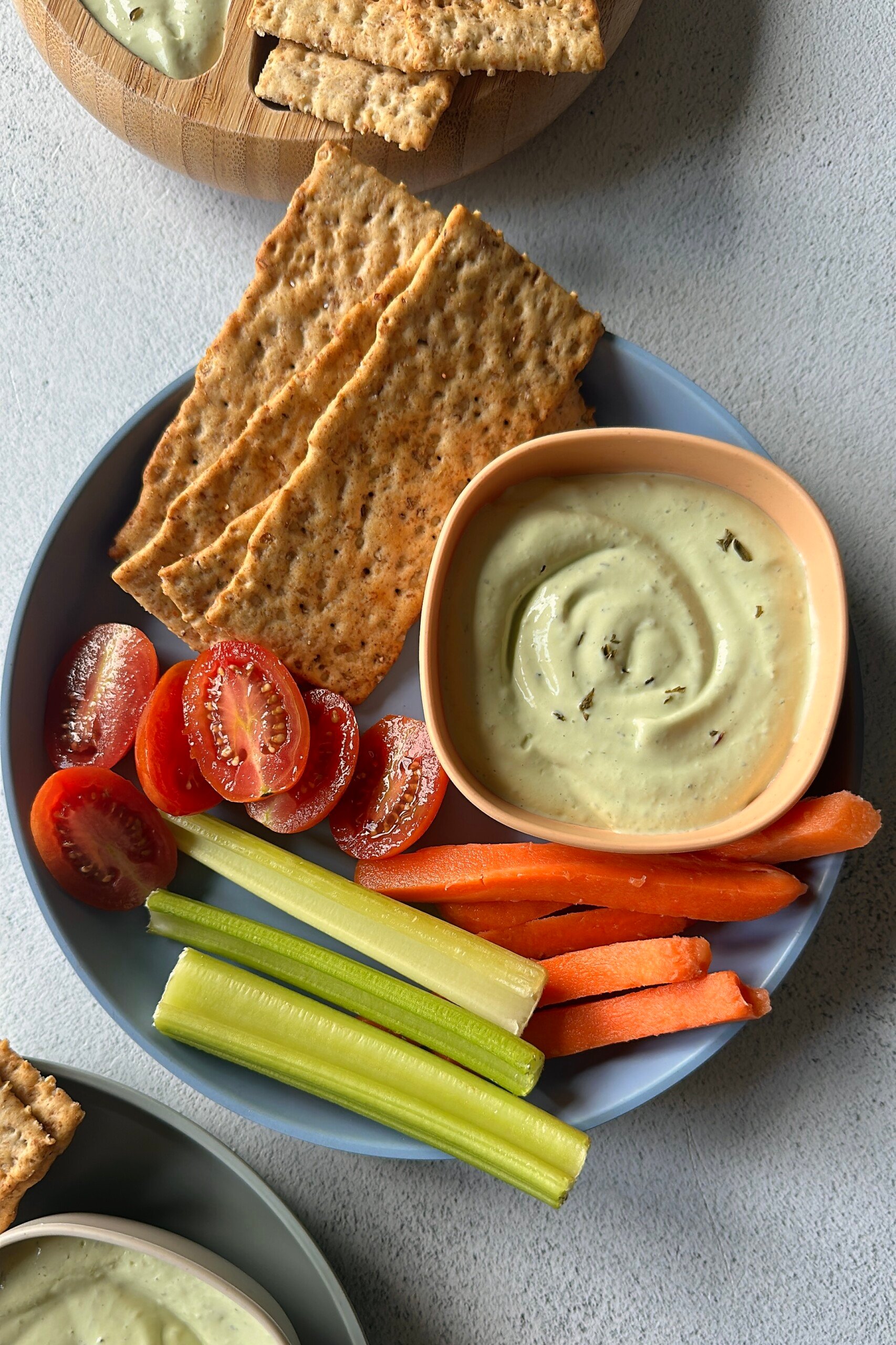 Avocado cottage cheese dip served with veggies and crackers.