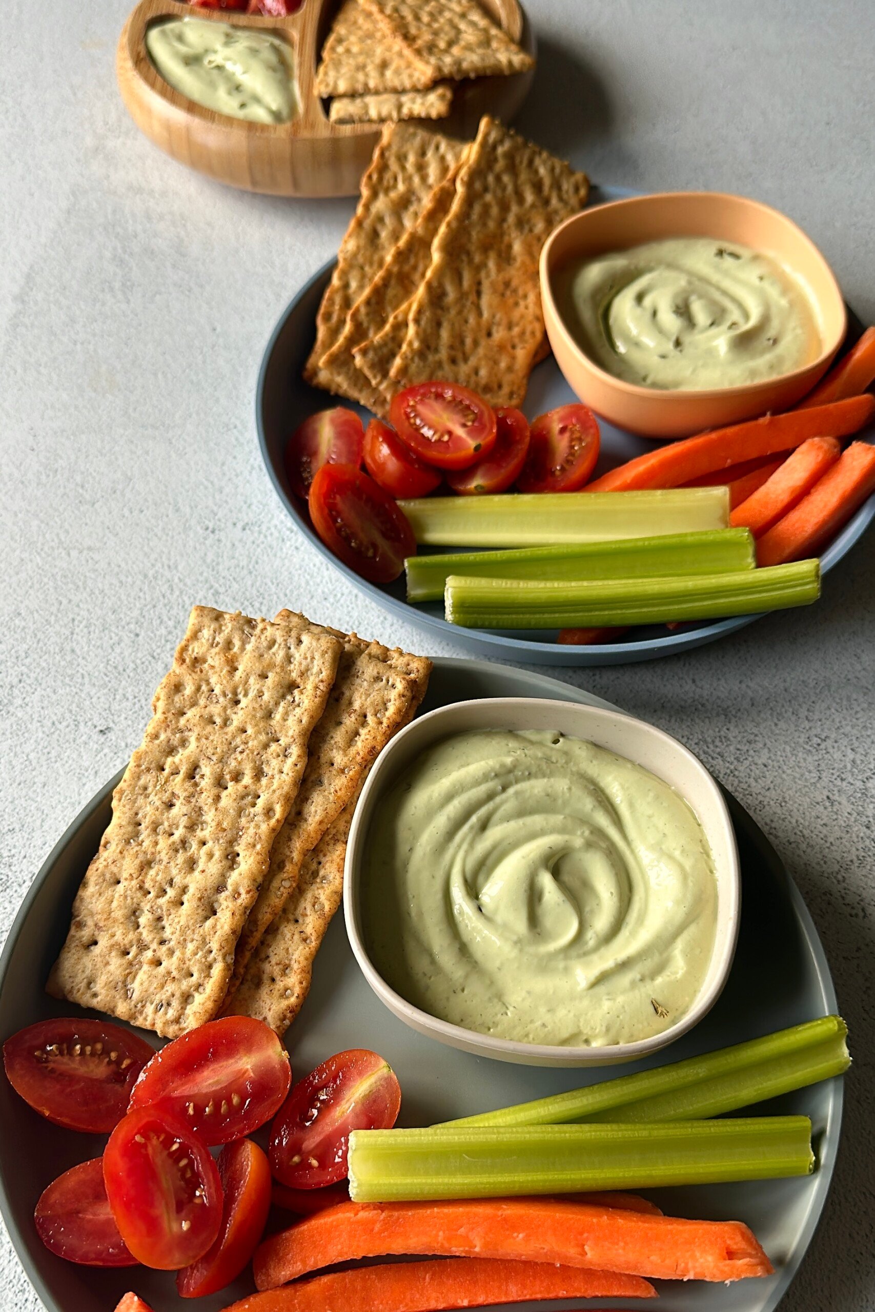 Avocado cottage cheese dip served with veggies and crackers.