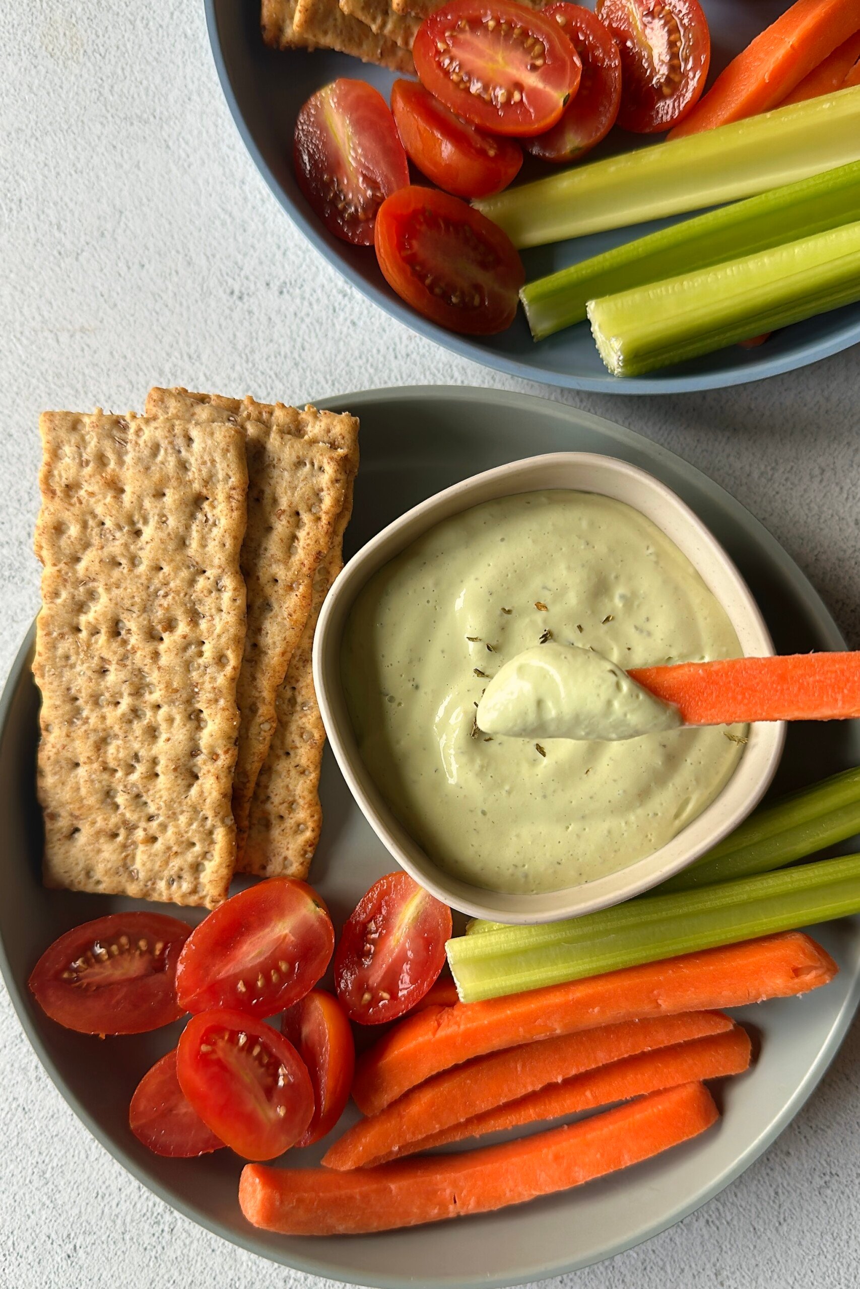 Avocado cottage cheese dip served with veggies and crackers.