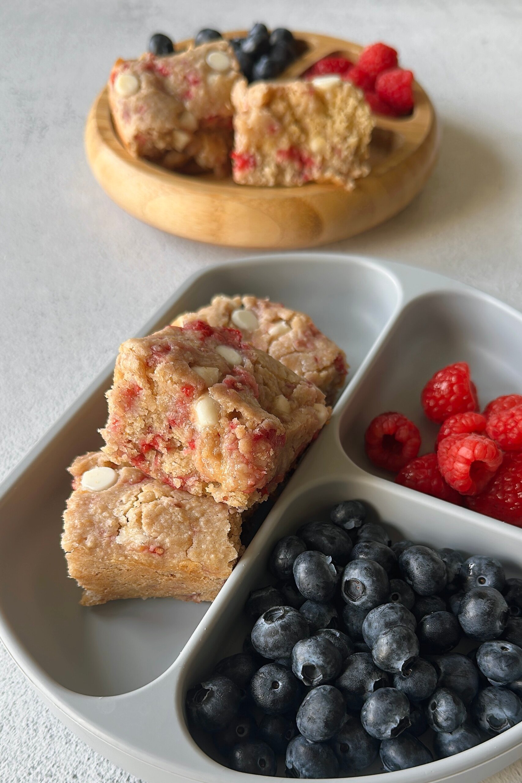 Raspberry white chocolate blondies served with berries.
