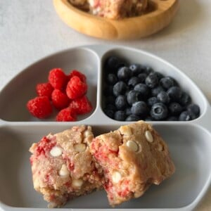 Raspberry white chocolate blondies served with berries.
