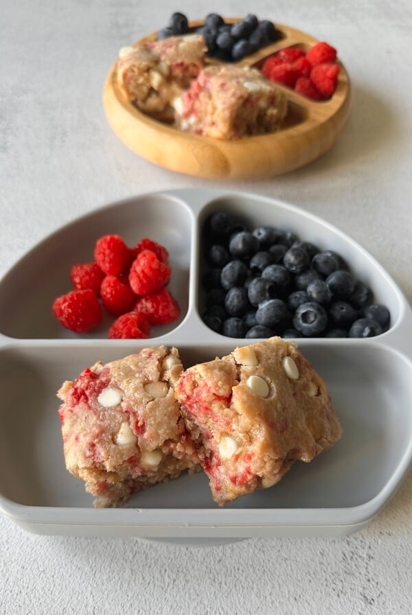 Raspberry white chocolate blondies served with berries.
