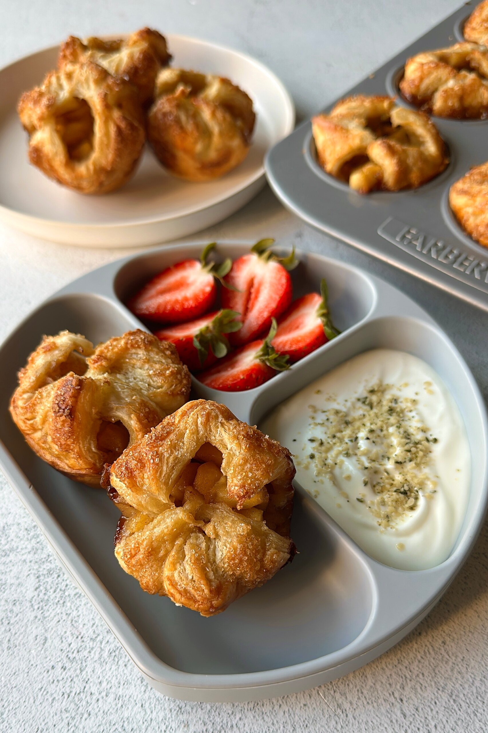 Baked apple croissant served with strawberries and yogurt.