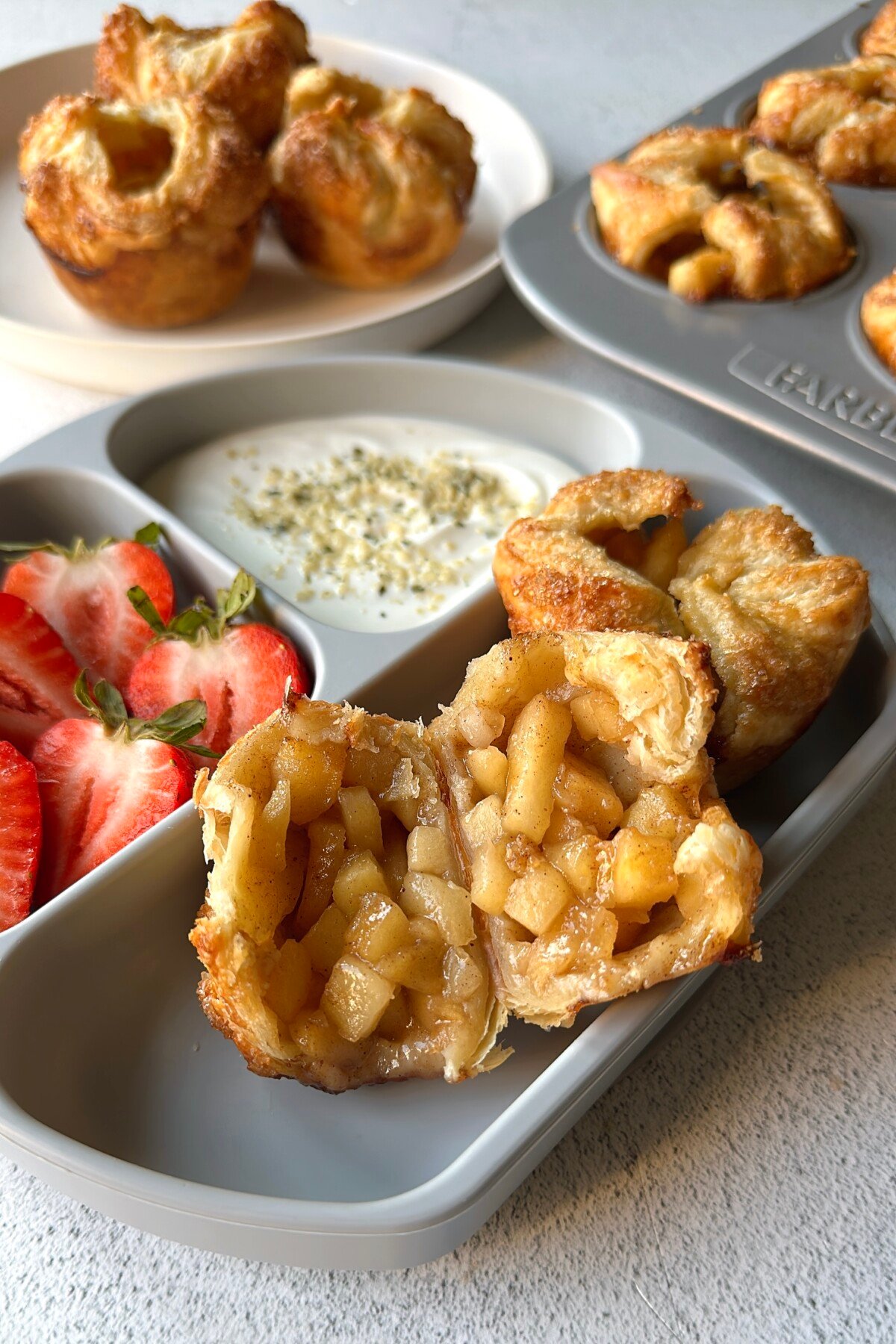 Baked apple croissant served with strawberries and yogurt.