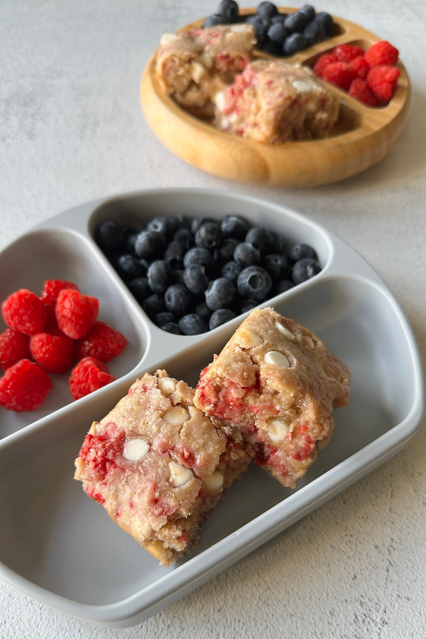 Raspberry white chocolate blondies served with berries.