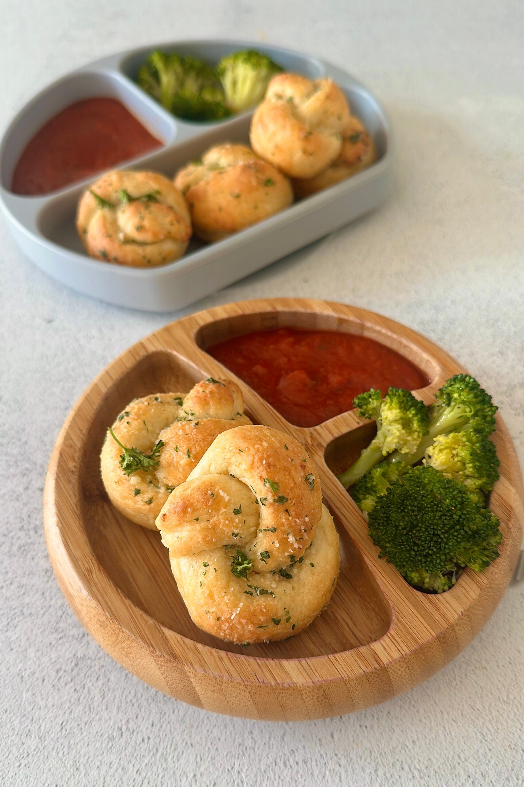 Garlic knots served with marinara sauce and broccoli.