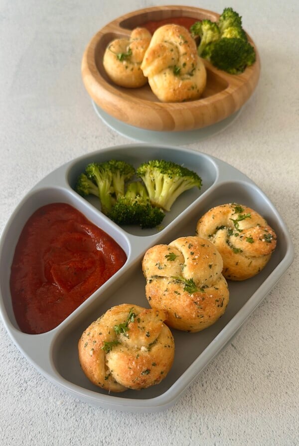 Garlic knots served with marinara sauce and broccoli.