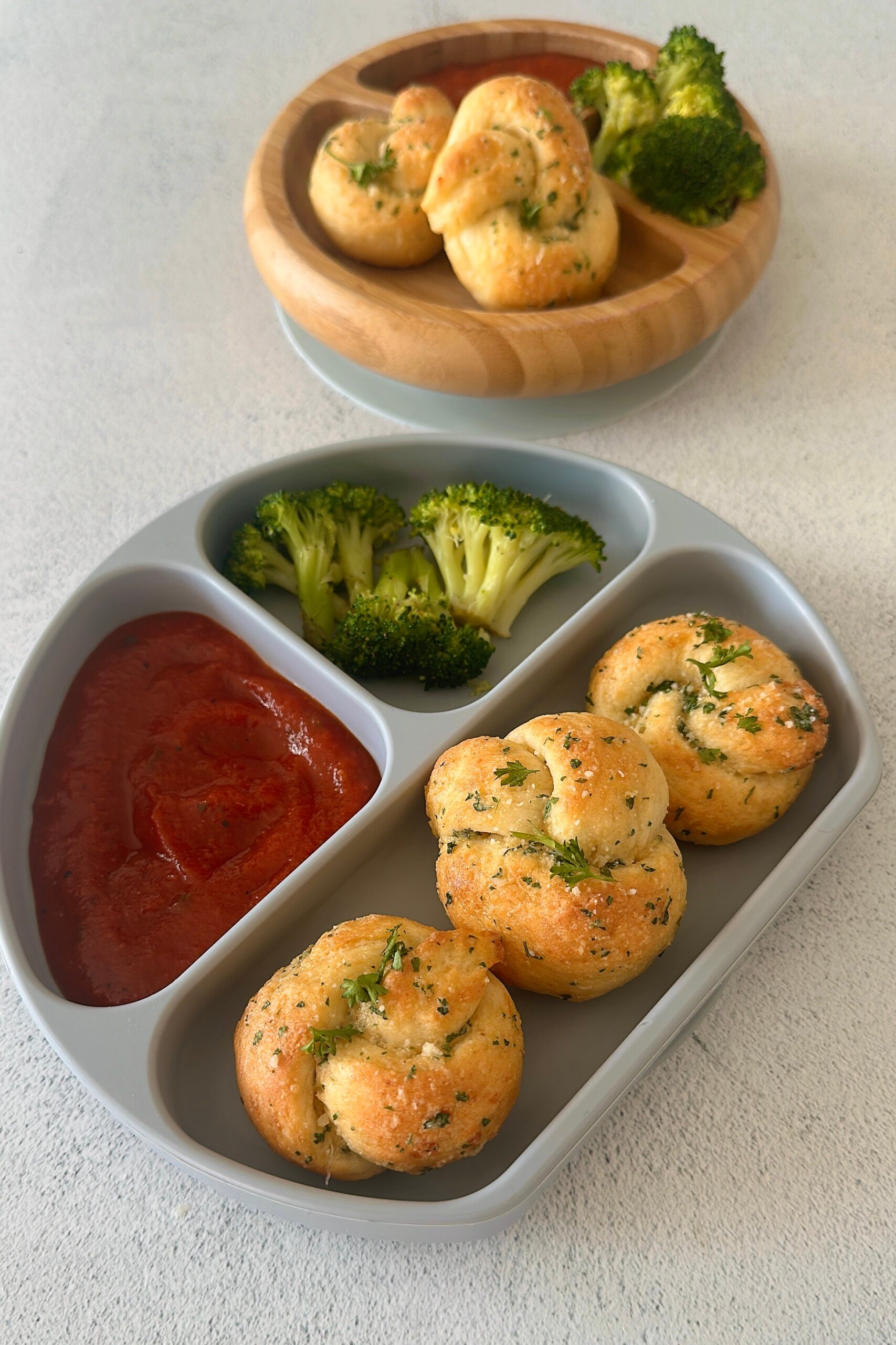 Garlic knots served with marinara sauce and broccoli.
