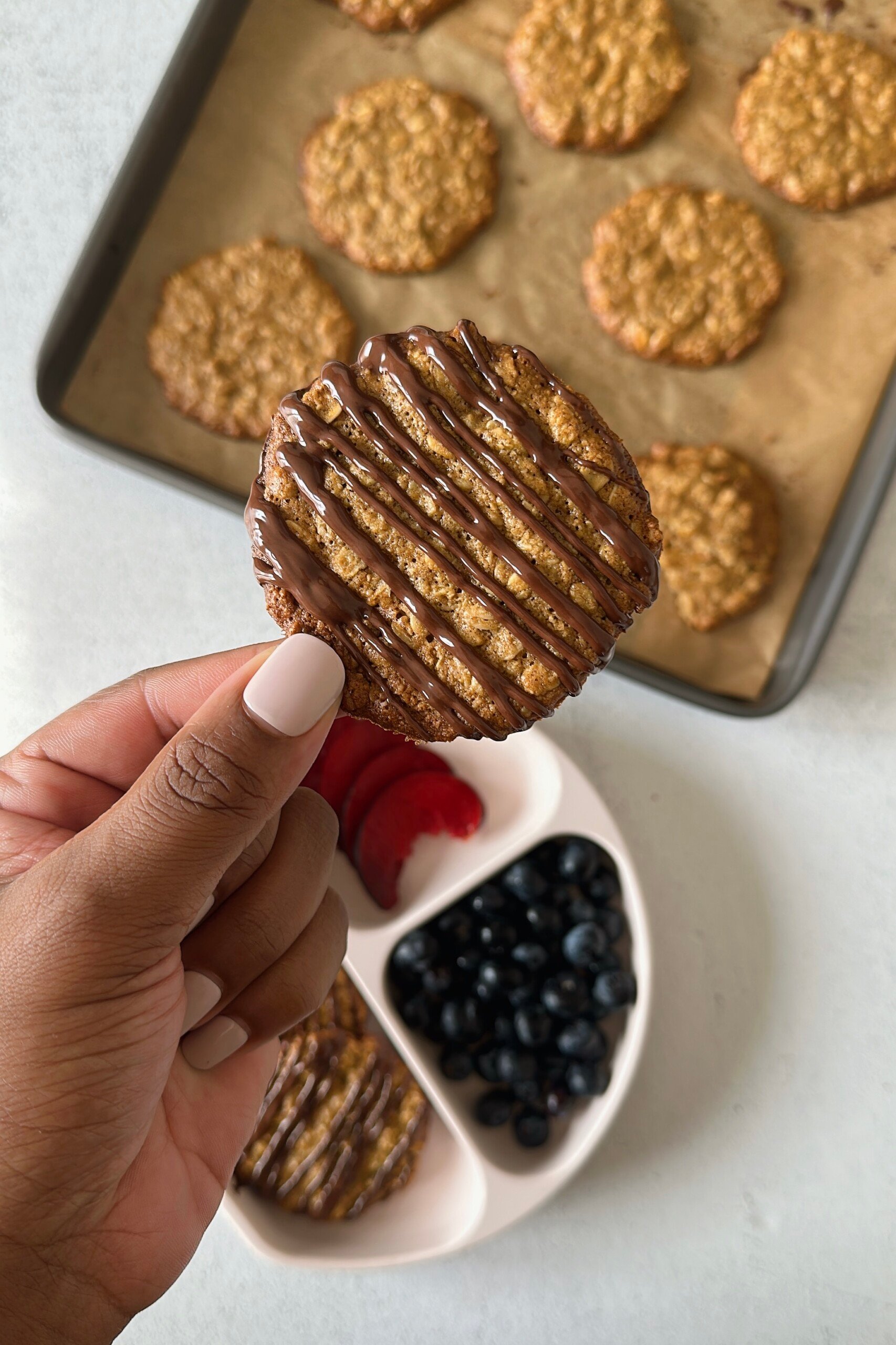 Crispy oatmeal cookies with a drizzle of chocolate on top.