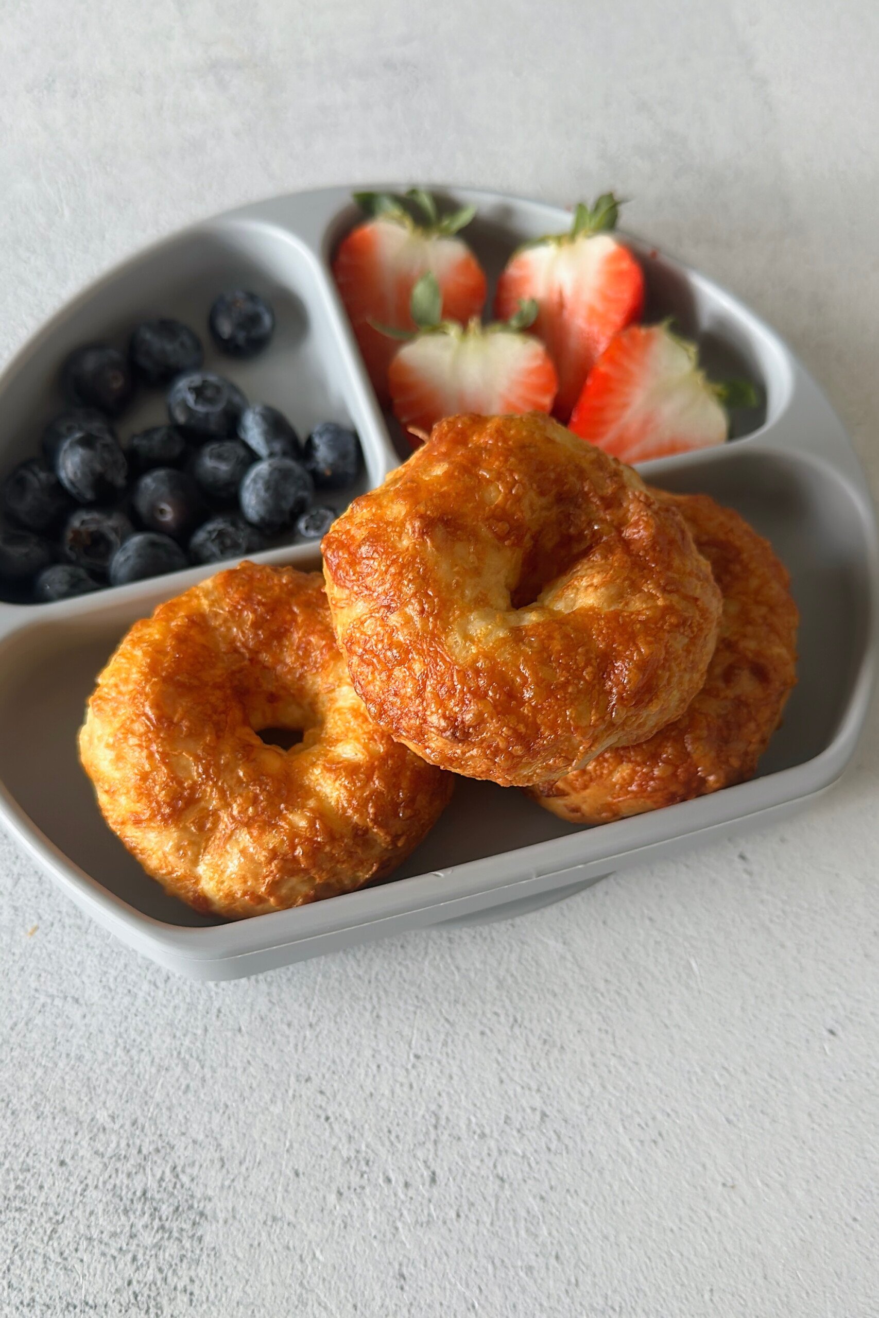 Cheddar bagels served with fruits.