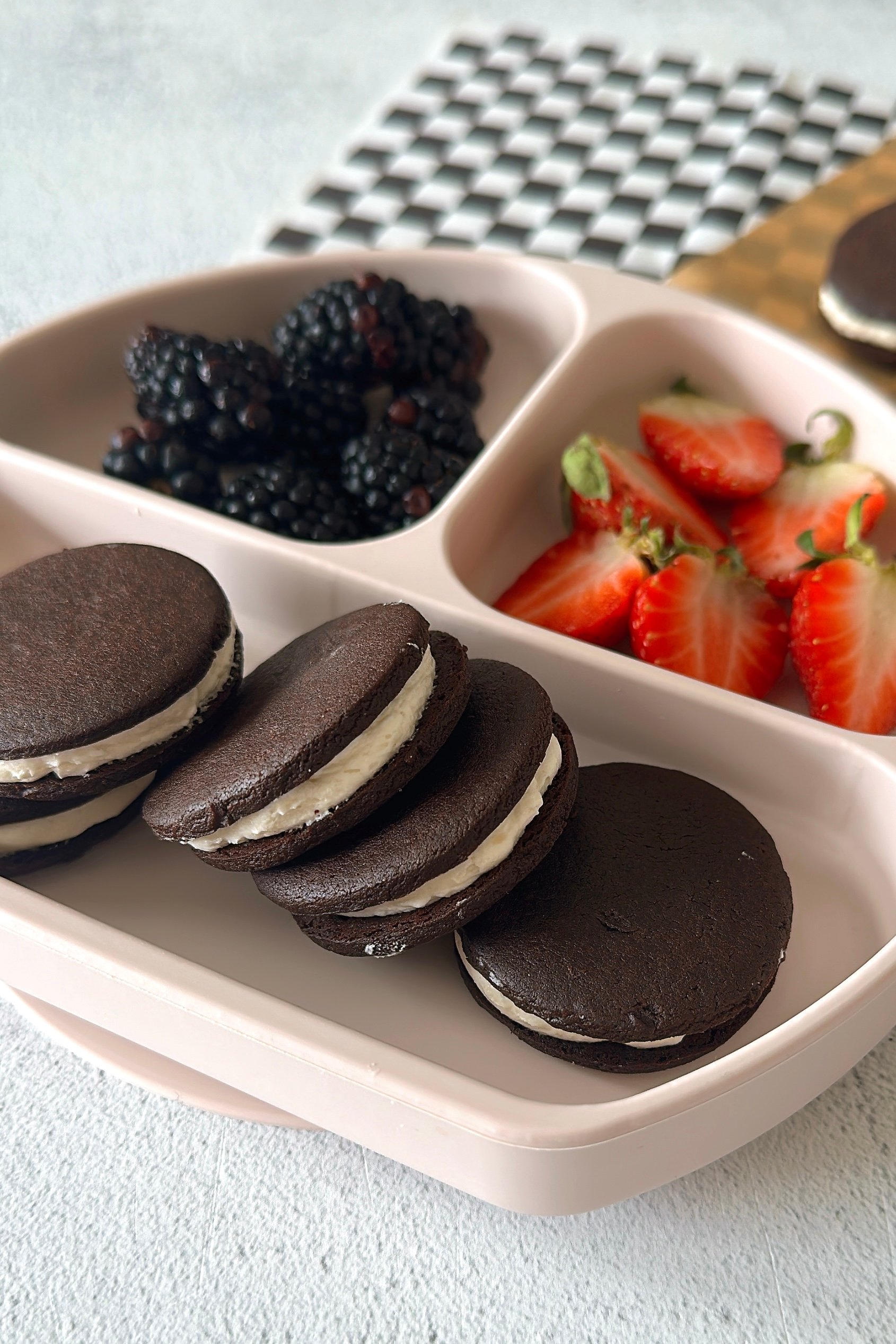 Homemade oreo cookies served with berries.