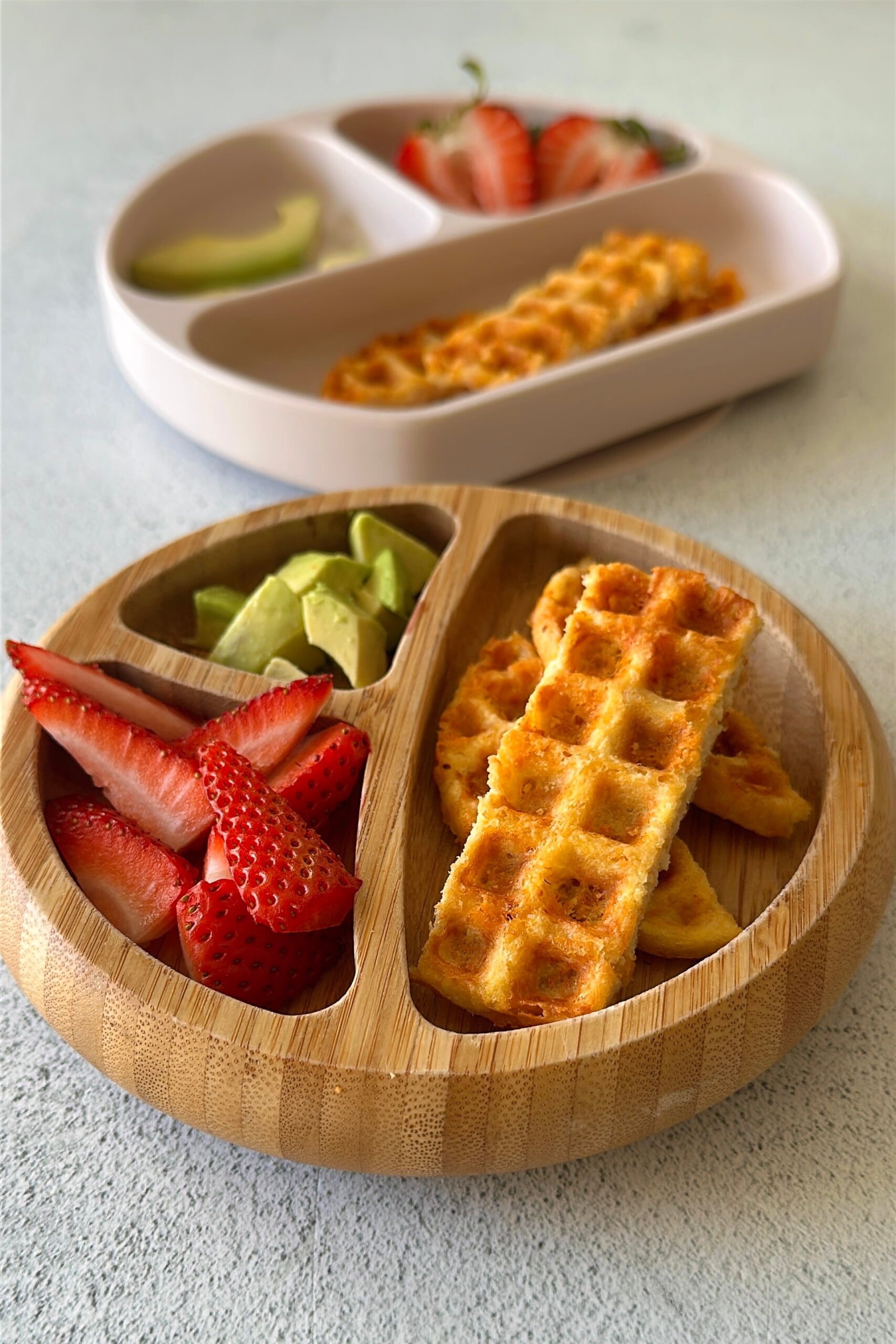 3 ingredient chicken waffles served with ketchup, avocado chunks, and strawberries.