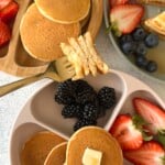 Fluffy mini pancakes served with berries.