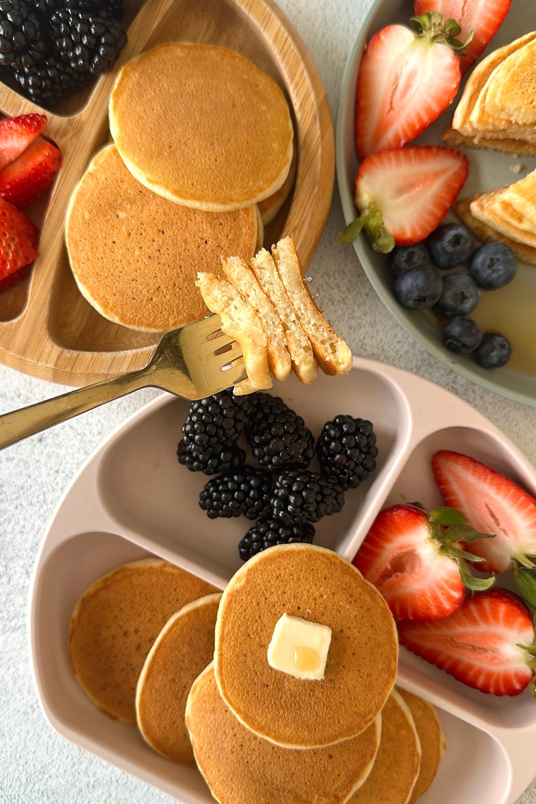 Fluffy mini pancakes served with berries.