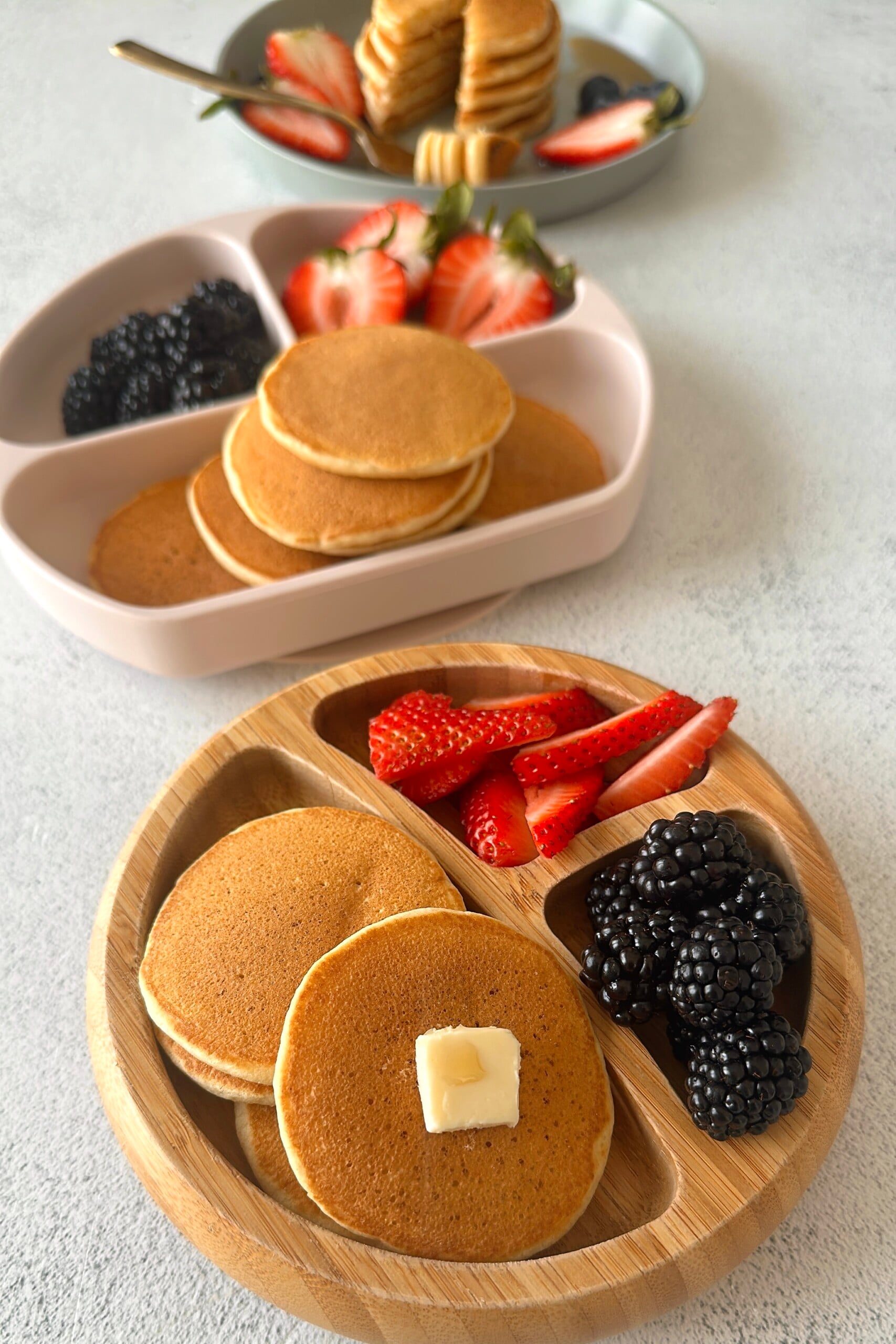 Fluffy mini pancakes served with berries.