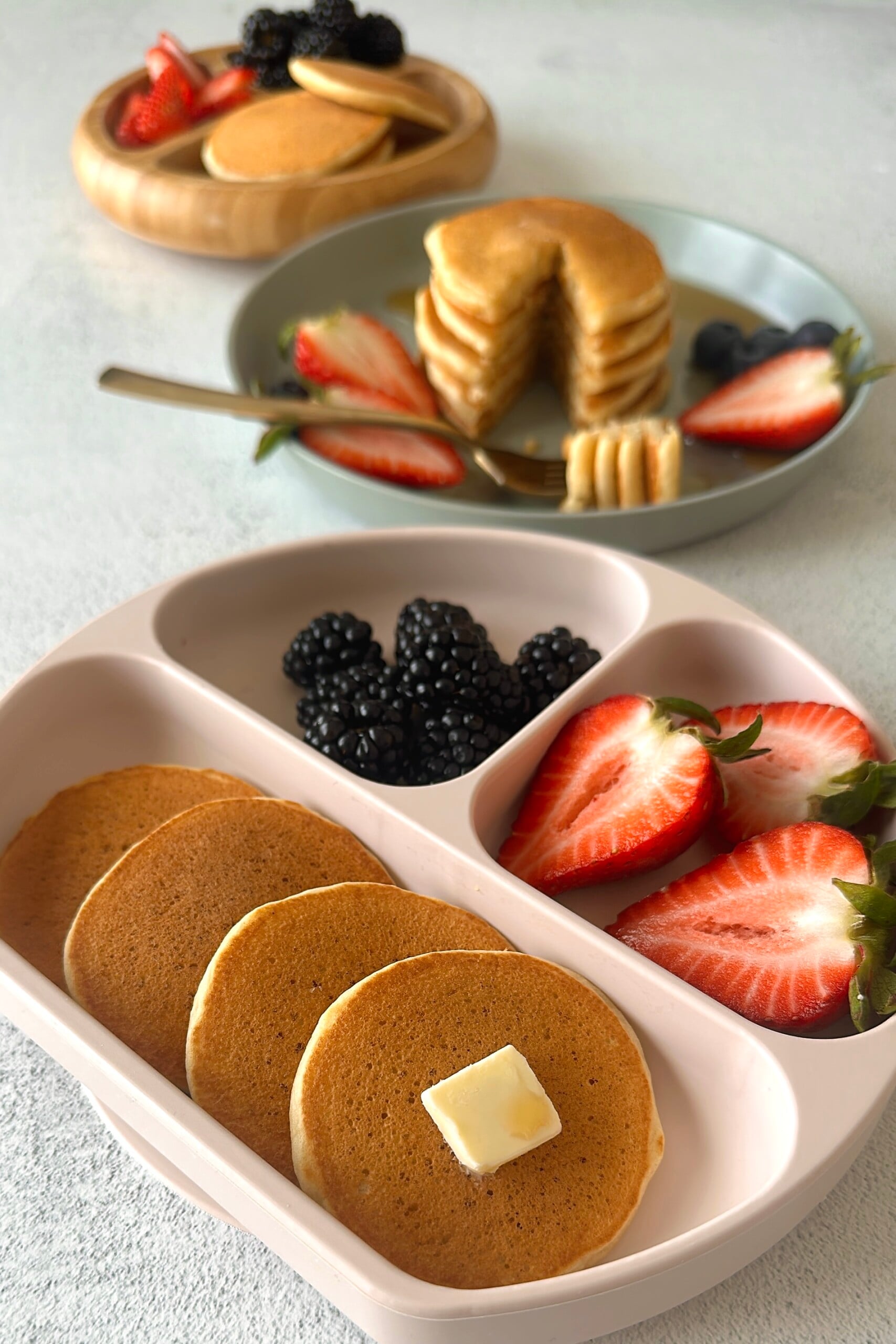 Fluffy mini pancakes served with berries.