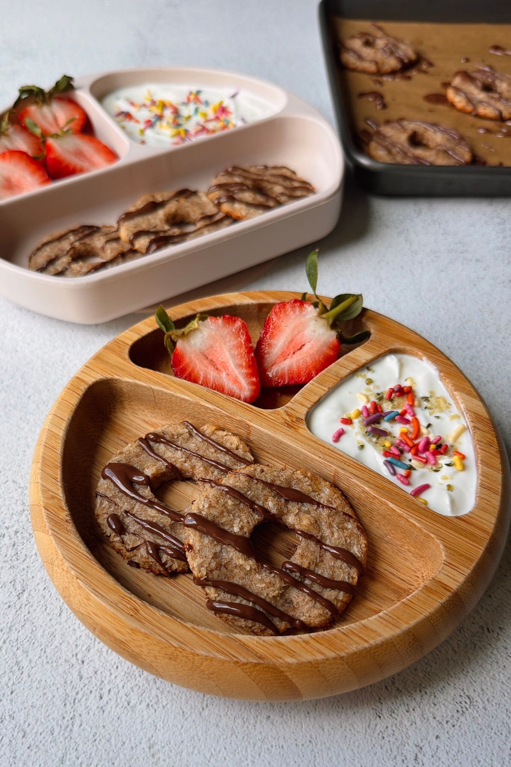 Coconut banana cookies served with yogurt and strawberries.