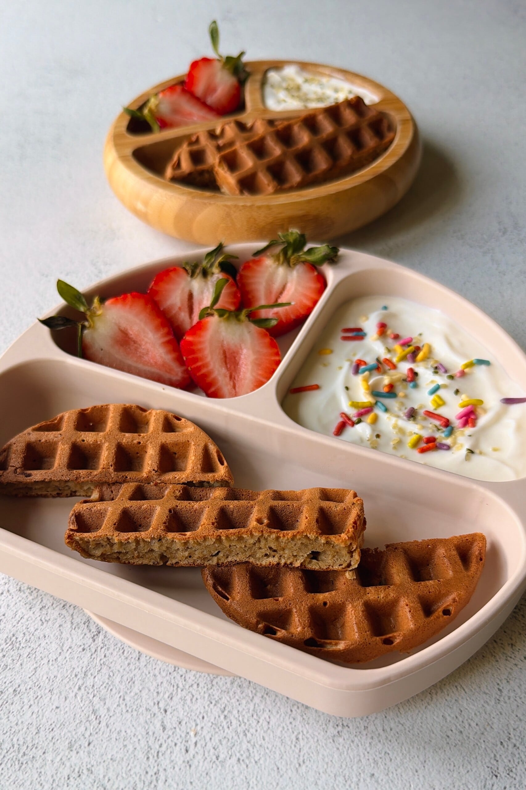 Banana oat waffles served with berries and yogurt.