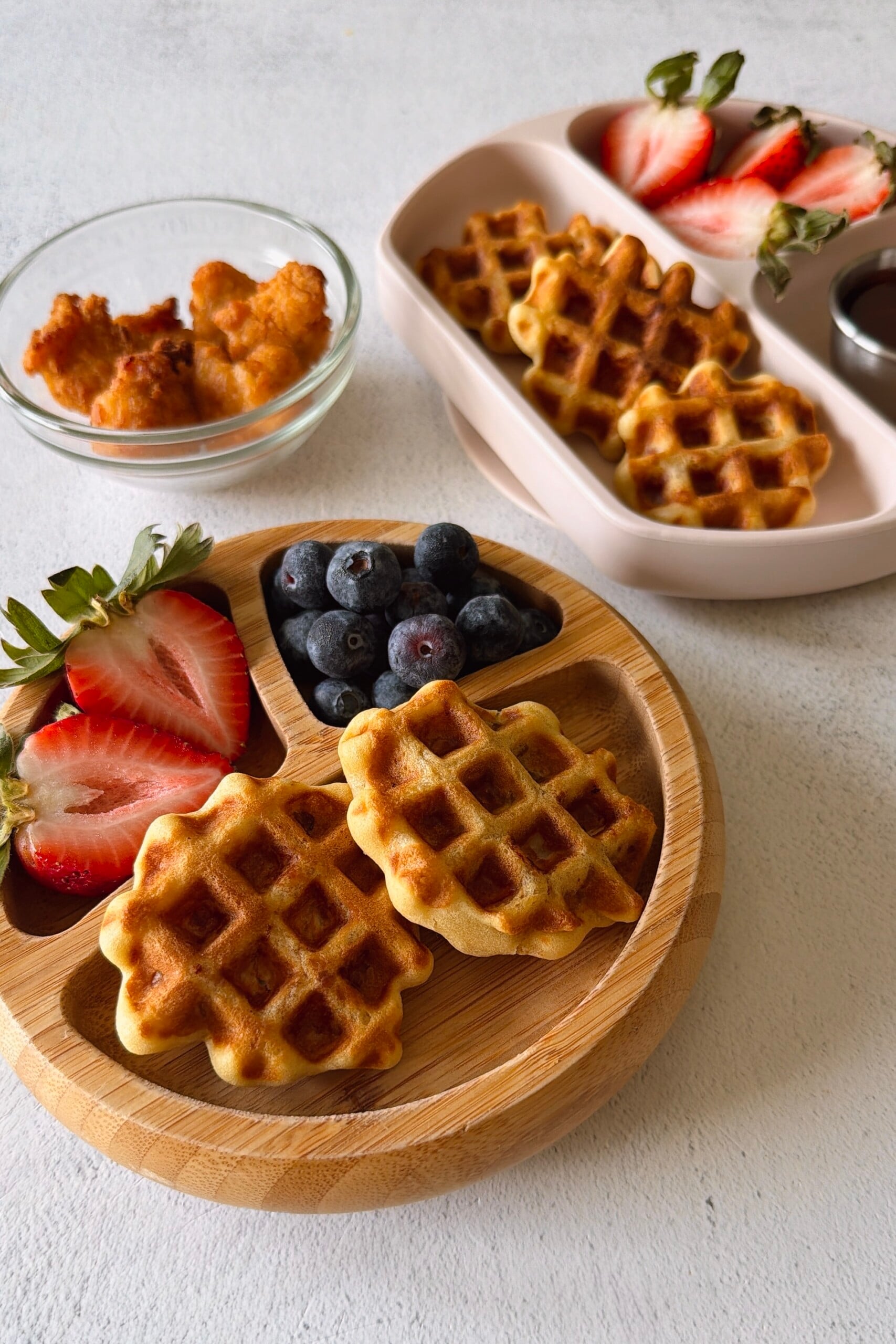 Chicken waffle bites served with berries and maple syrup.