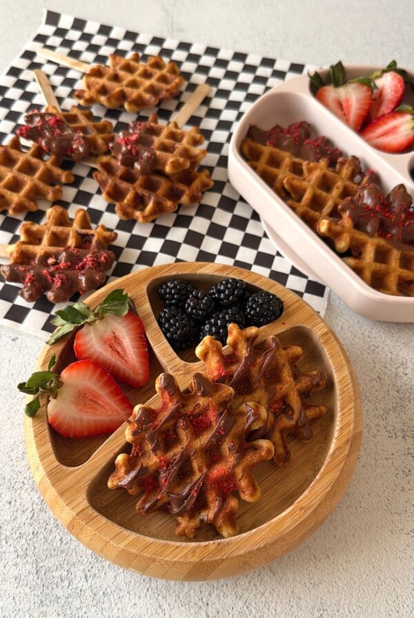 Chocolate strawberry waffles served on a plate with berries.