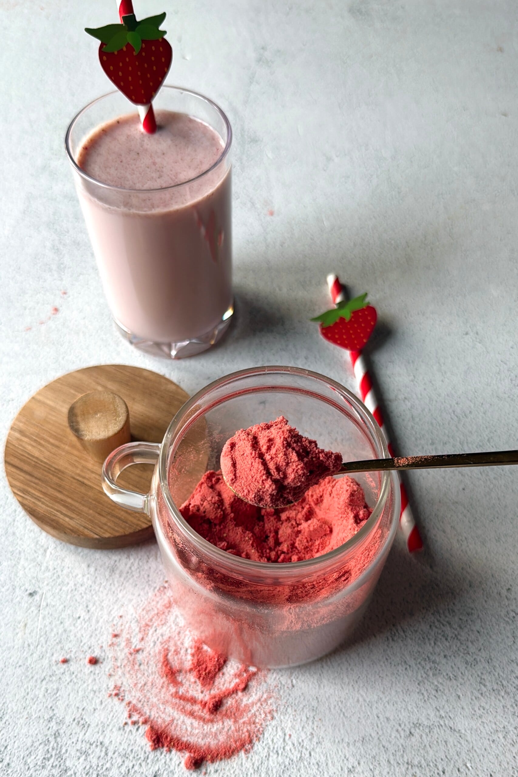 Strawberry milk powder with a glass of strawberry milk.