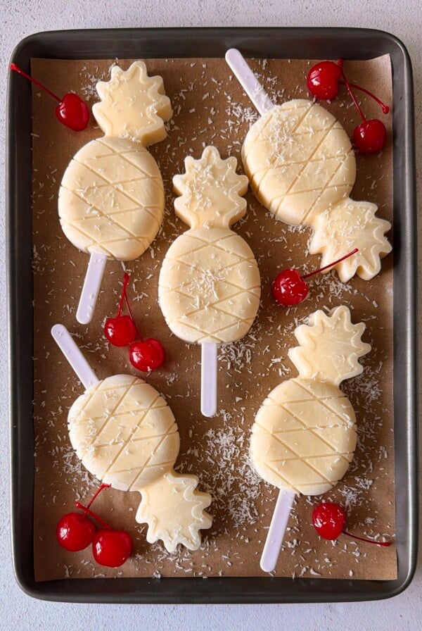 Pina colada popsicles on a tray.
