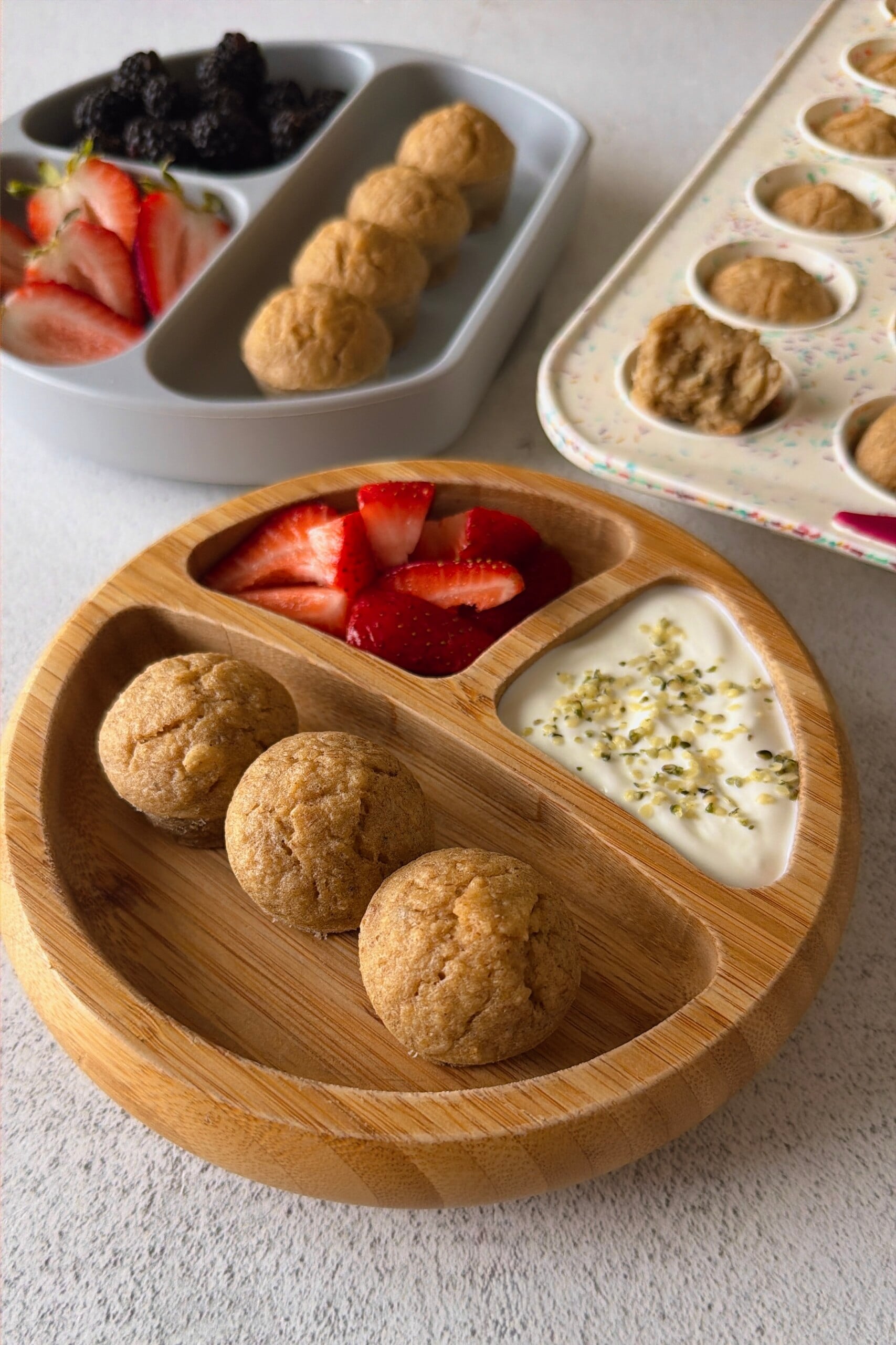Banana oat flour muffins served with berries and yogurt.