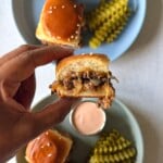 Cheeseburger sliders served with pickles and a burger sauce.