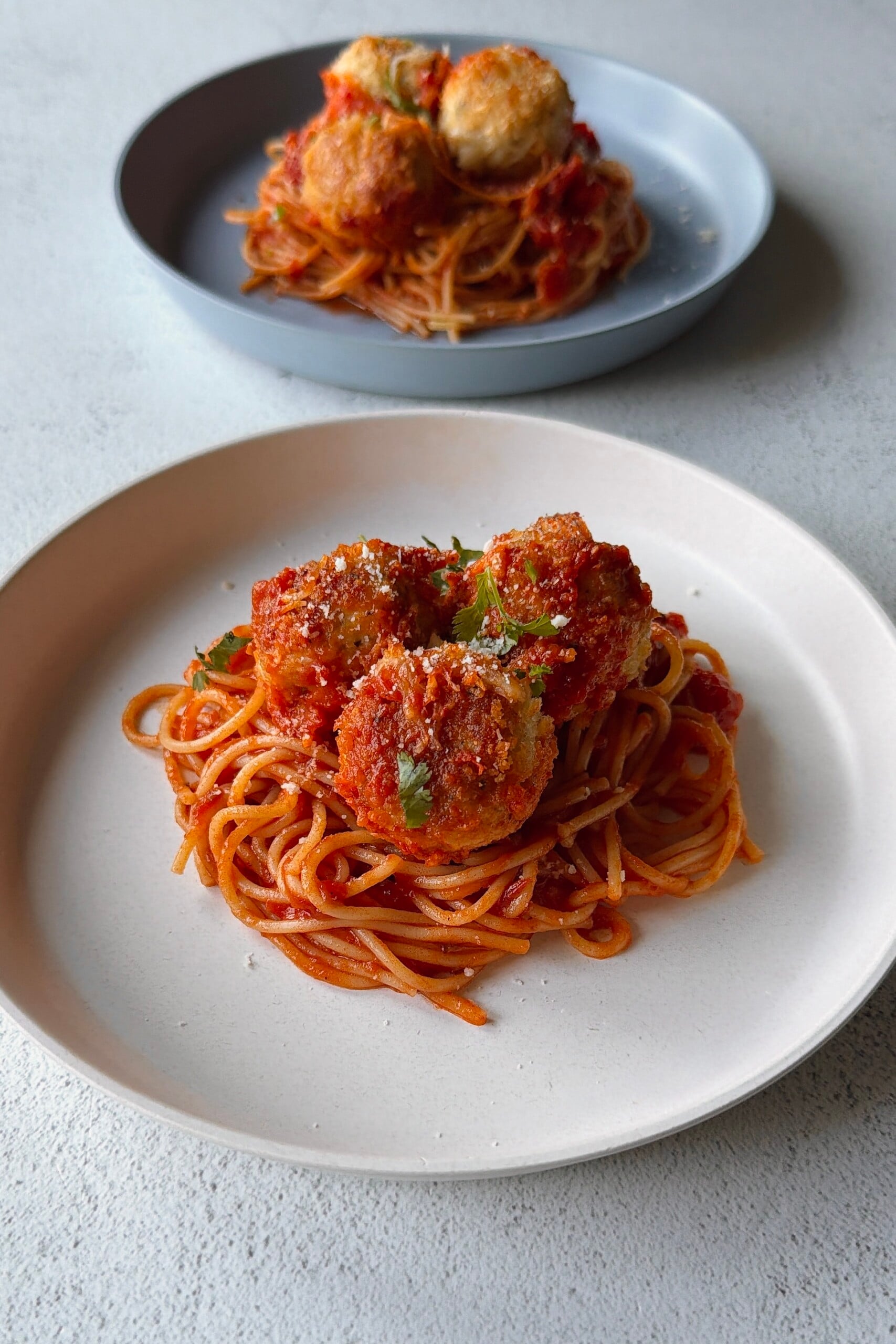 Chicken parm meatballs served with spaghetti.