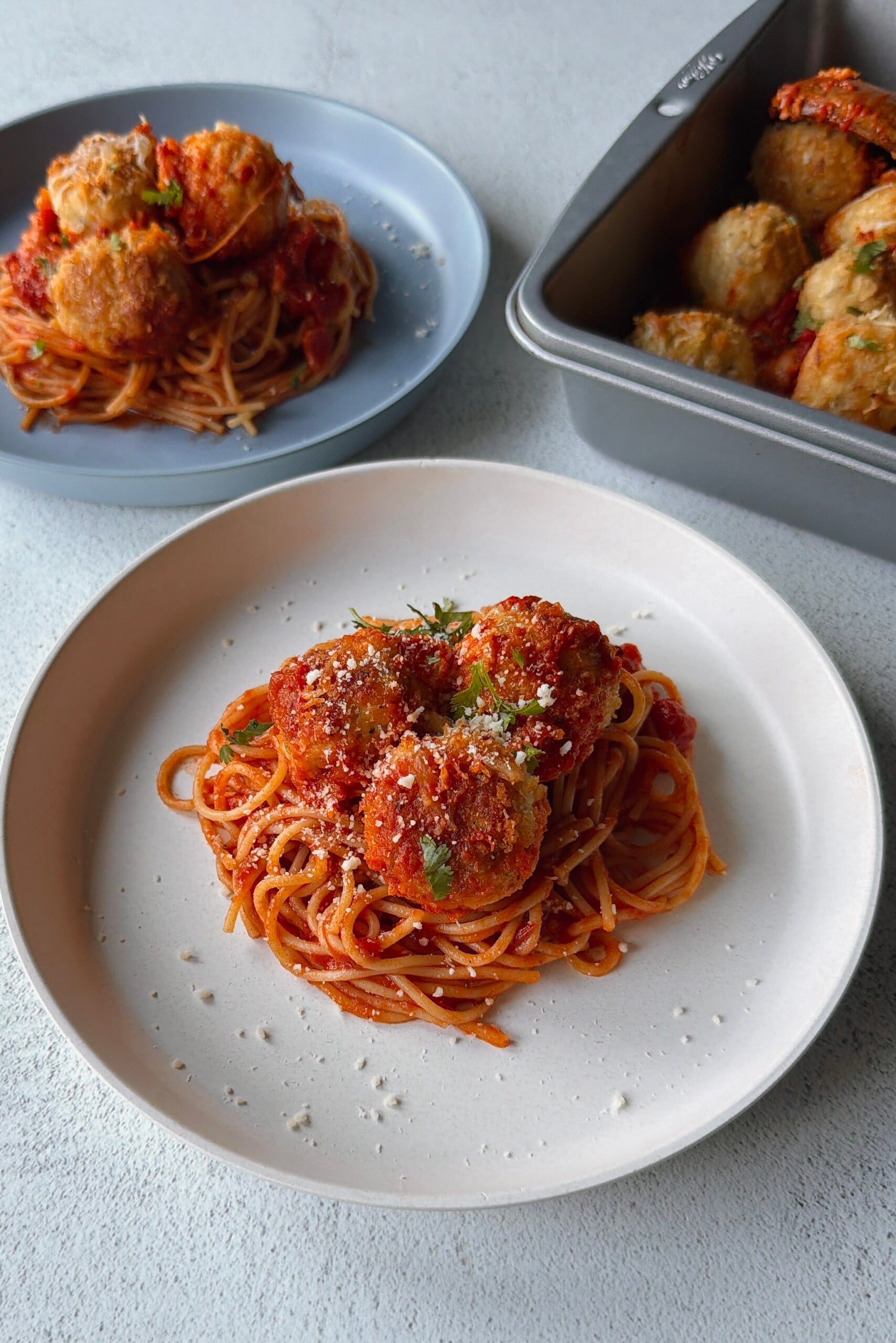Chicken parm meatballs served with spaghetti.