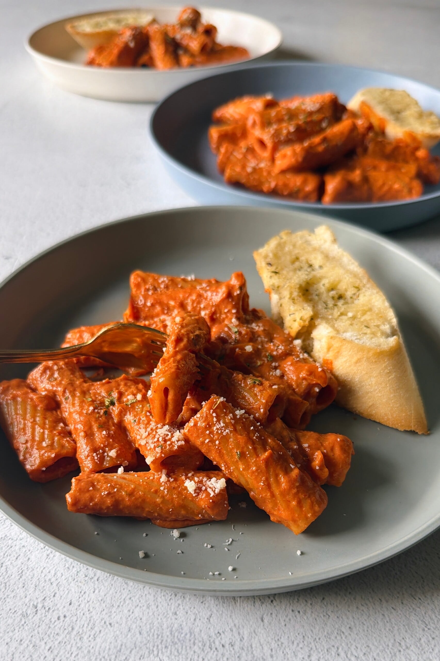 Creamy tomato pasta served with garlic bread.