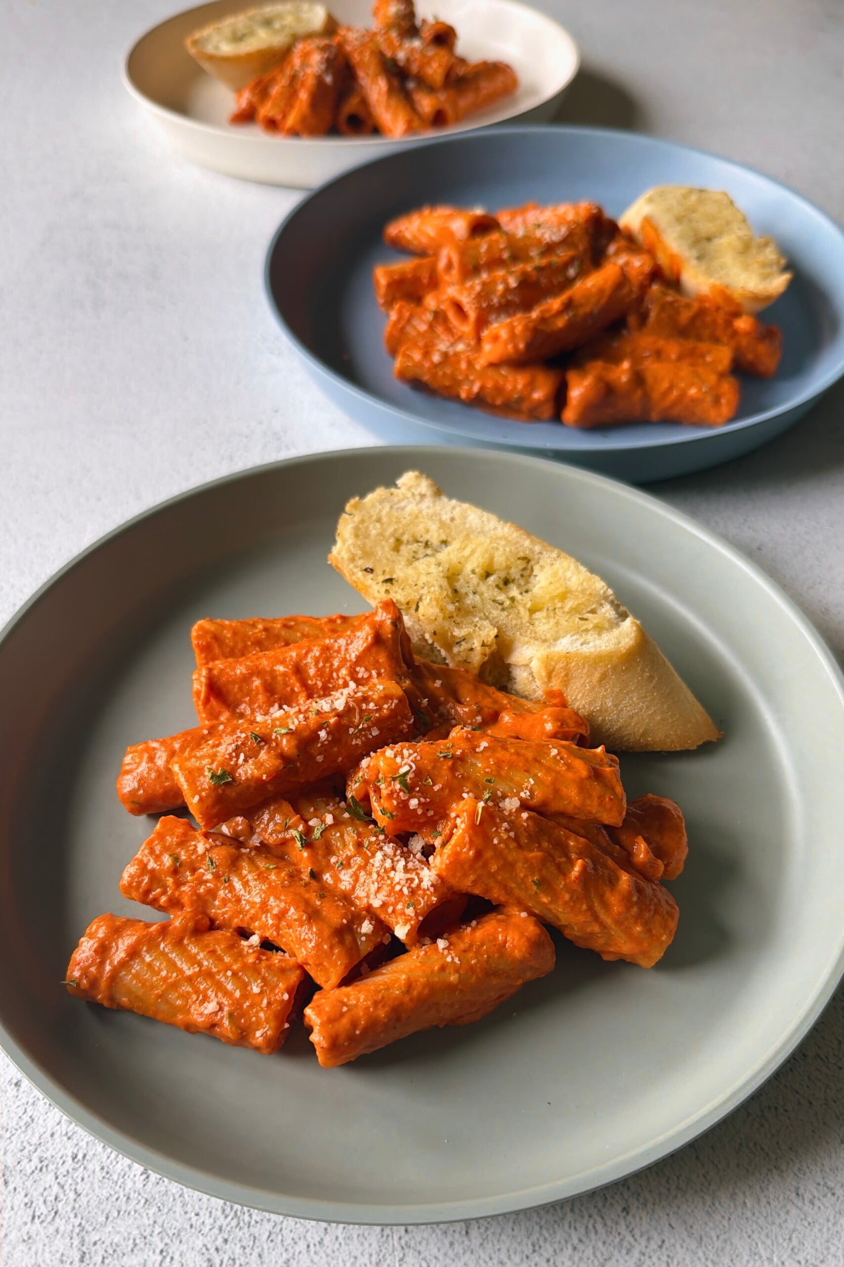 Creamy tomato pasta served with garlic bread.