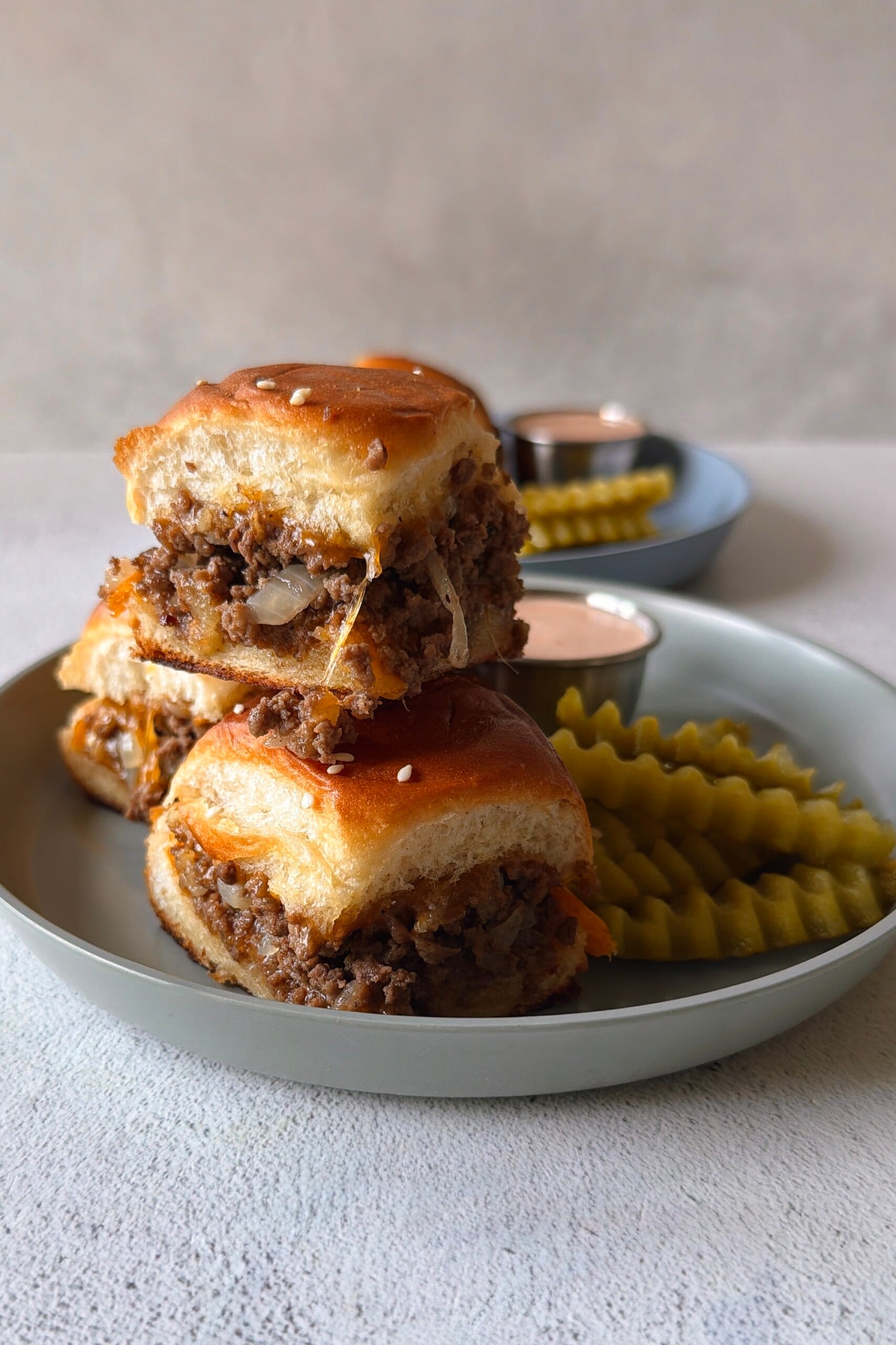 Cheeseburger sliders served with pickles and a burger sauce.
