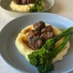 Garlic butter steak bites served with mashed potatoes and broccolini.