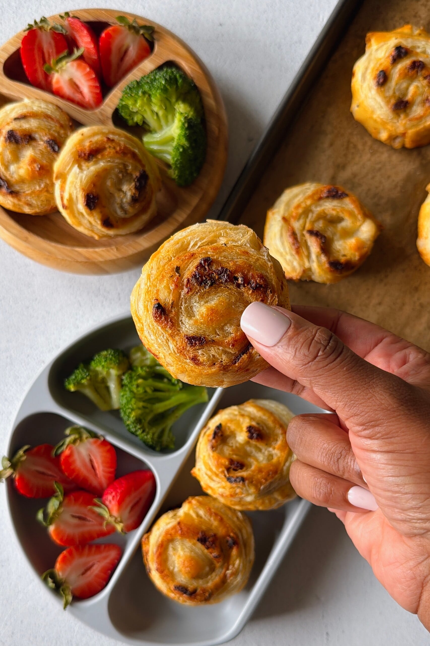 Cheese and tomato pinwheels served with broccoli and strawberries.