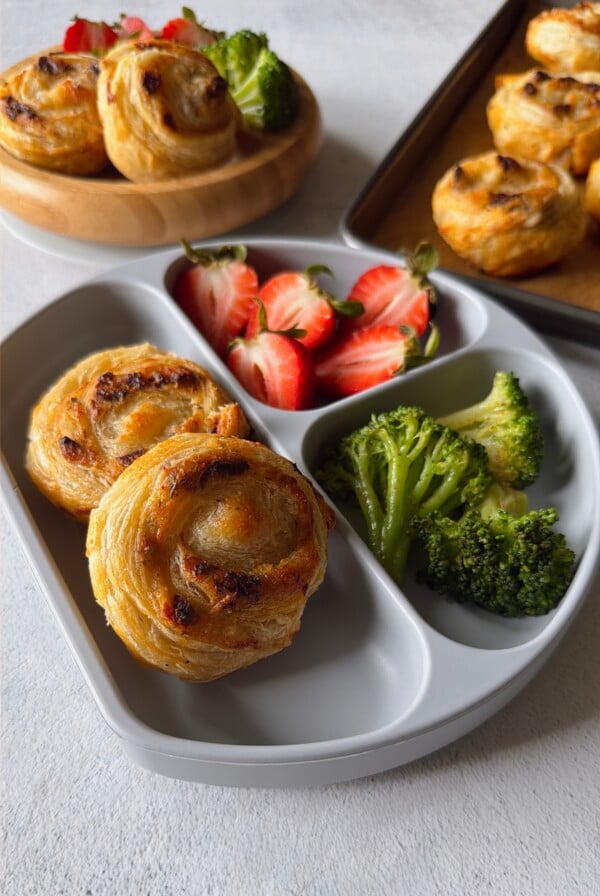 Cheese and tomato pinwheels served with broccoli and strawberries.