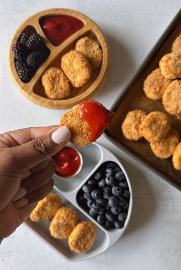 Cauliflower chicken nuggets served with ketchup and berries.