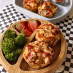 Pizza cups served with pizza sauce for dipping, strawberries, and broccoli.