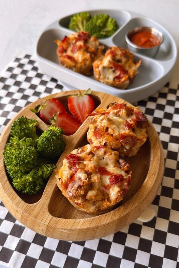 Pizza cups served with pizza sauce for dipping, strawberries, and broccoli.