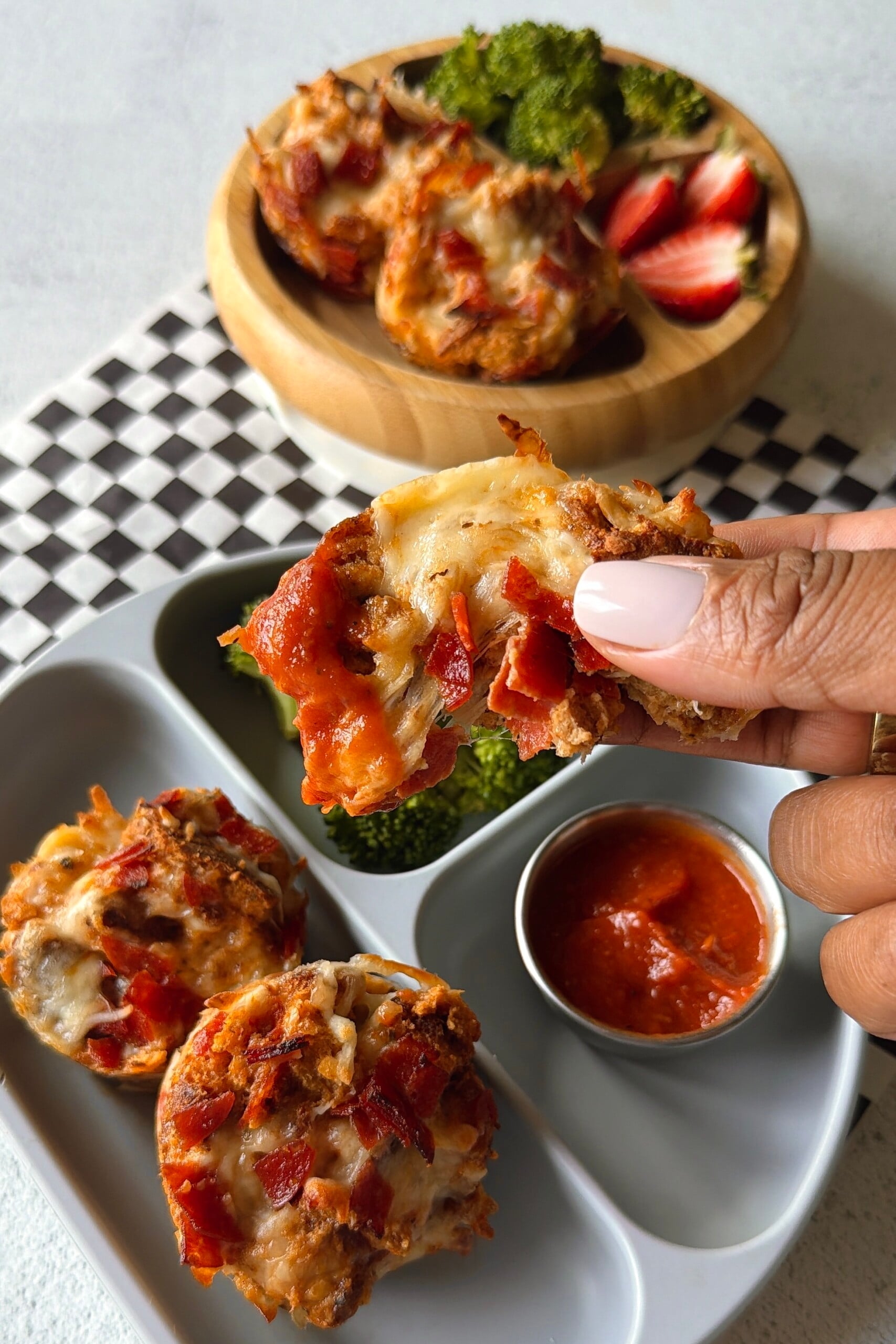 Pizza cups served with pizza sauce for dipping, strawberries, and broccoli.