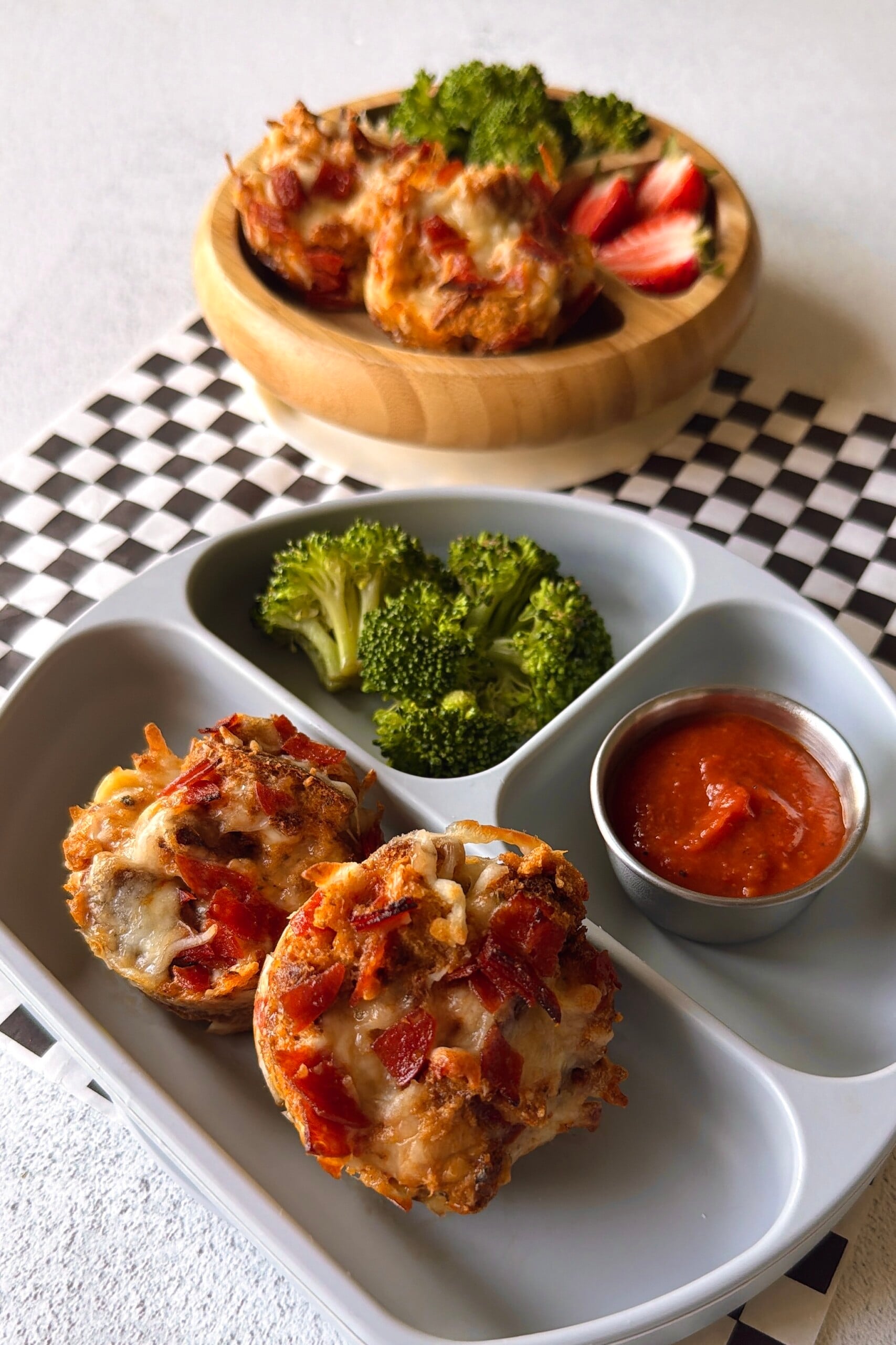 Pizza cups served with pizza sauce for dipping, strawberries, and broccoli.