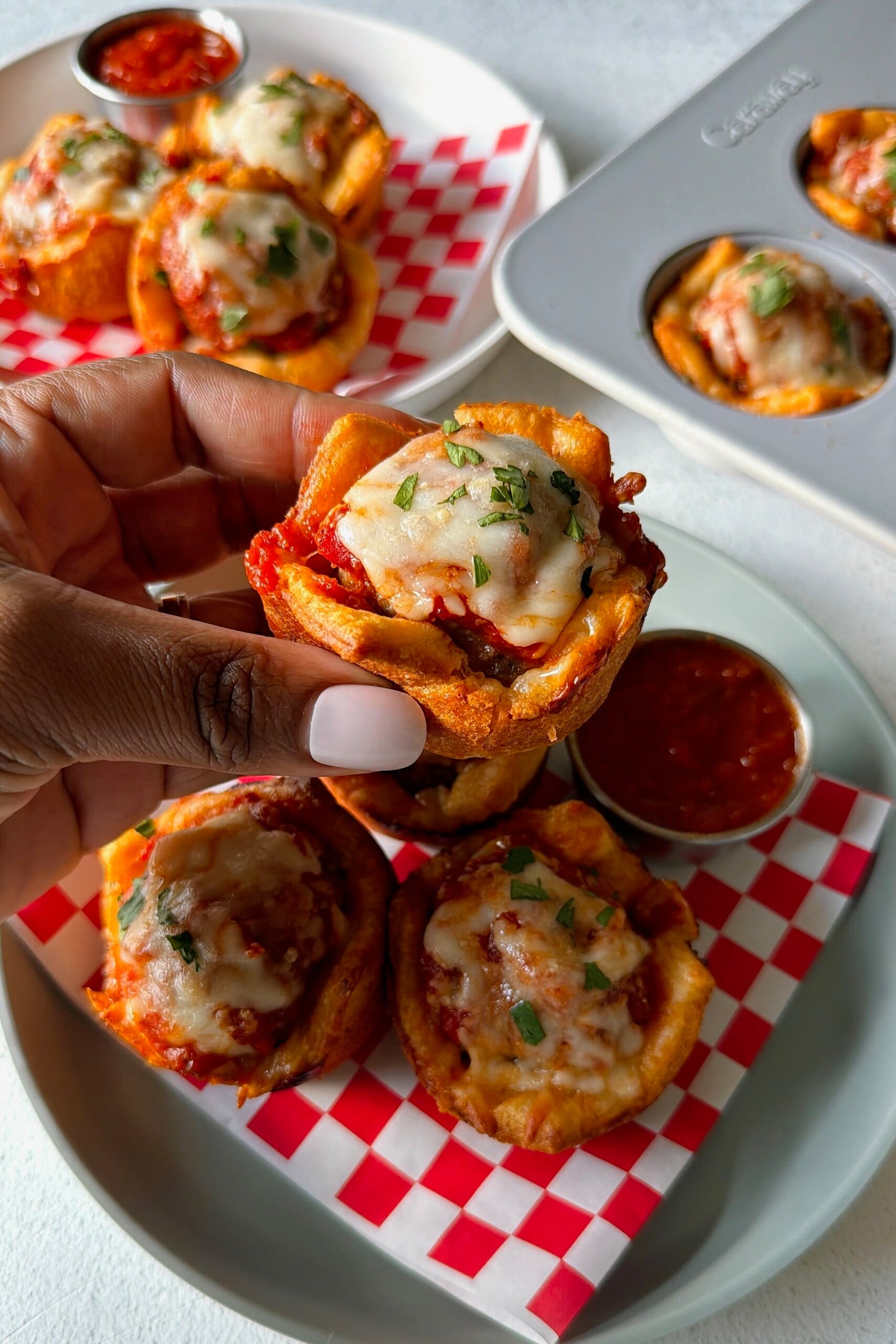 Meatball cups served with marinara sauce for dipping.