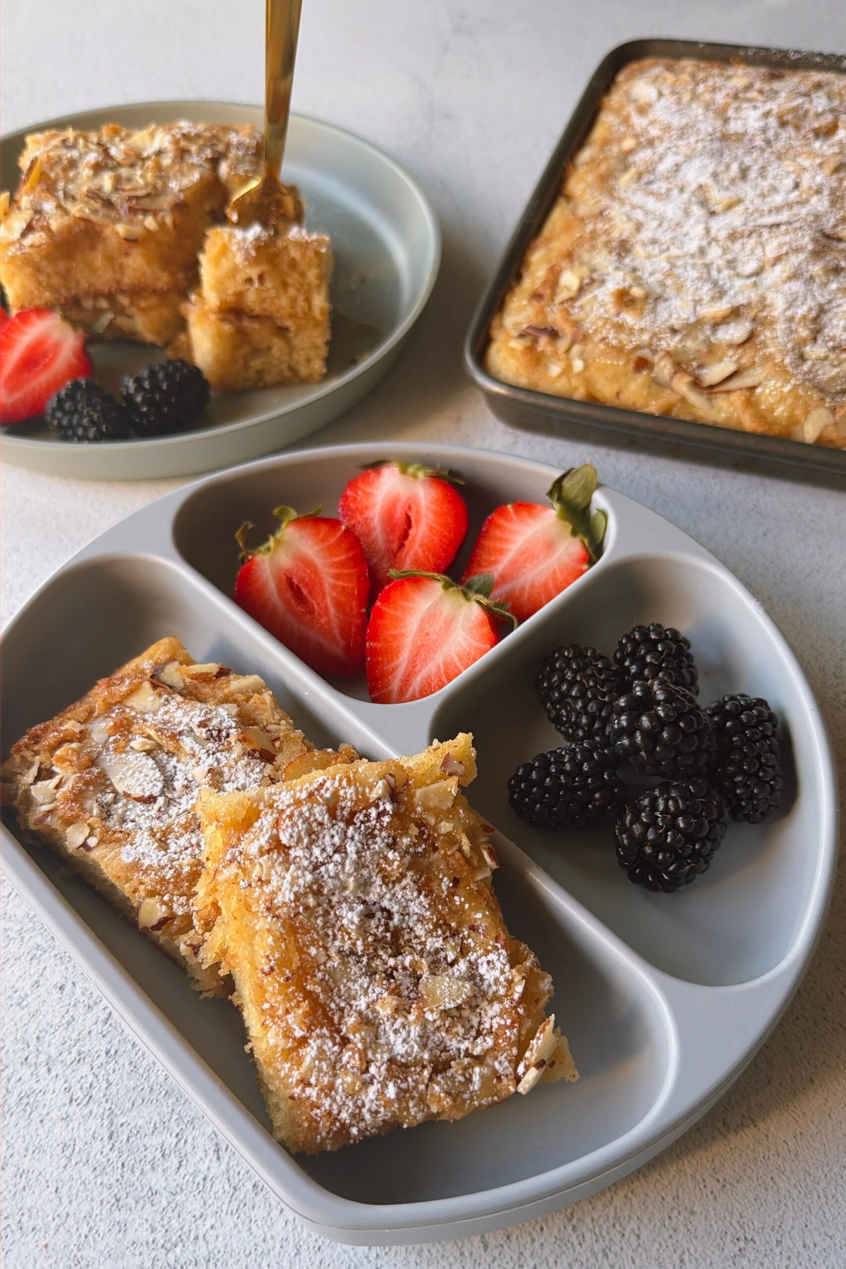 Almond croissant sheet pan pancakes served with berries.